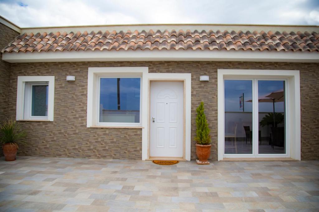 a brick house with a white door and windows at Il Granello in Fiumicino
