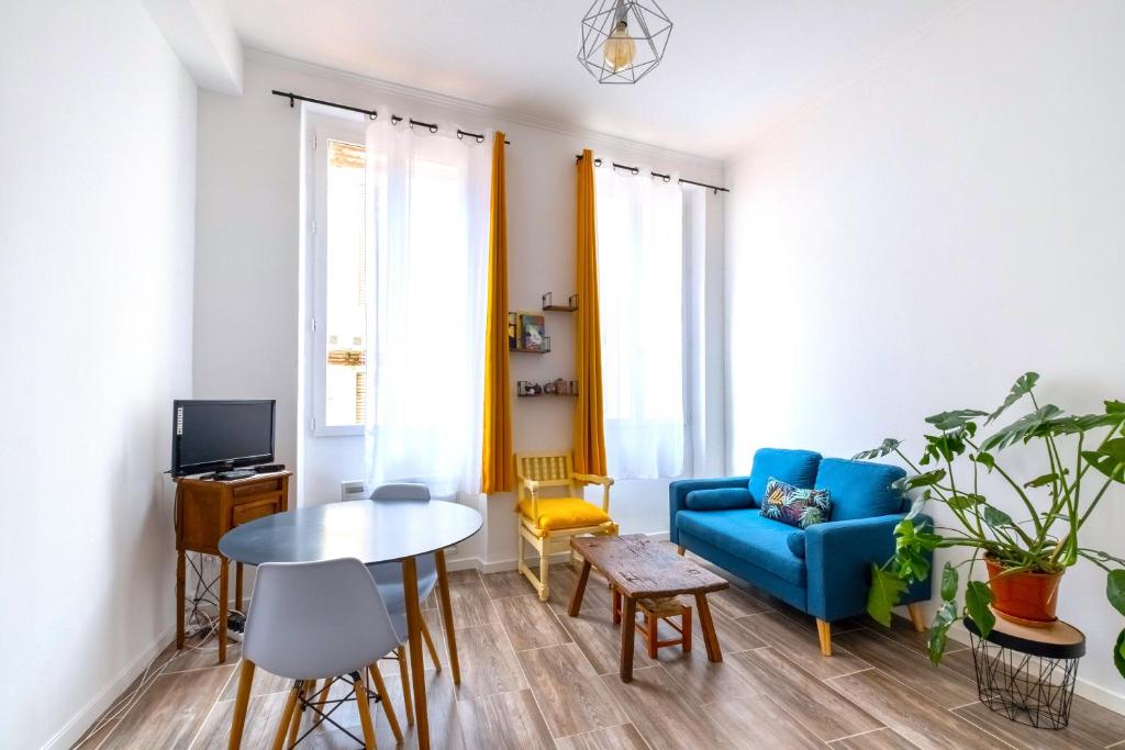 un salon avec un canapé bleu et une table dans l'établissement À 200M de la Gare Matabiau - Appartement tout équipé en Hypercentre -, à Toulouse