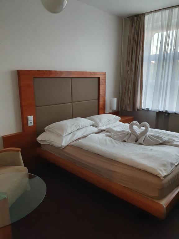 Un dormitorio con una cama con dos cisnes. en Hotel Jerabek en Praga
