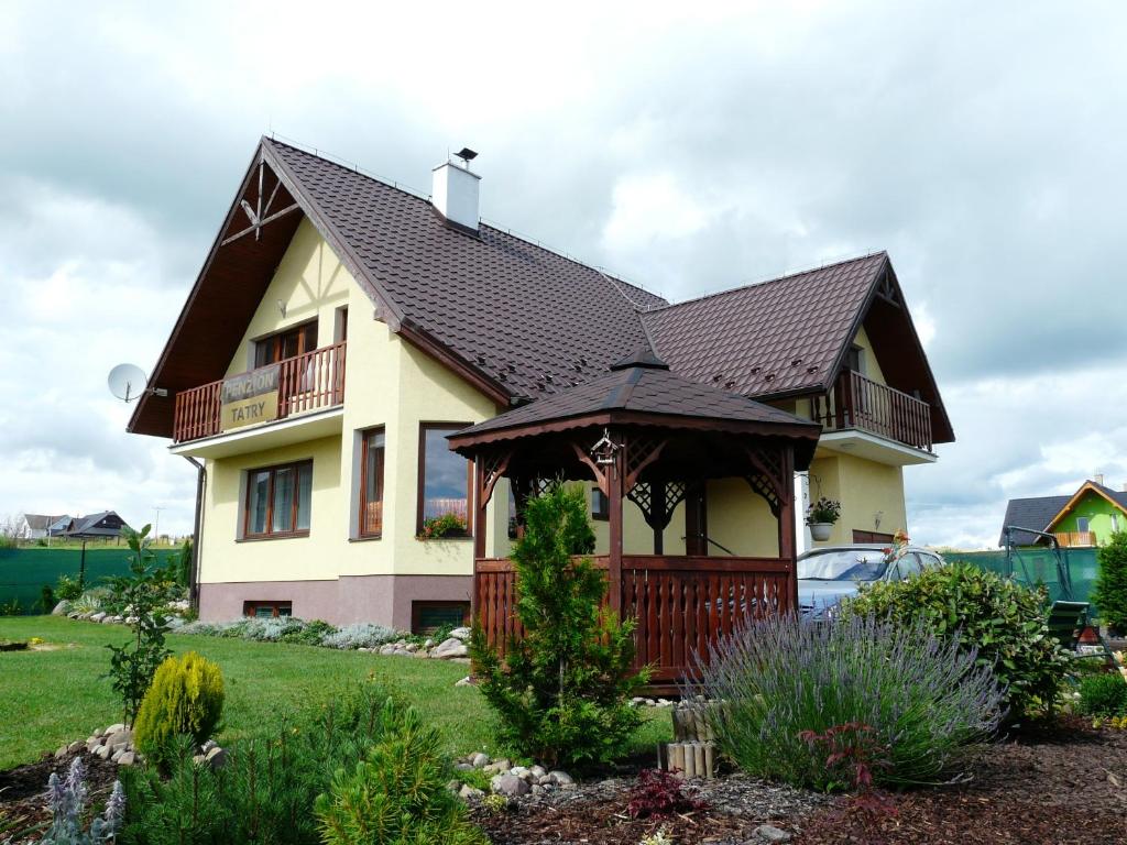 a house with a gazebo in a yard at Penzion Tatry in Veľká Lomnica