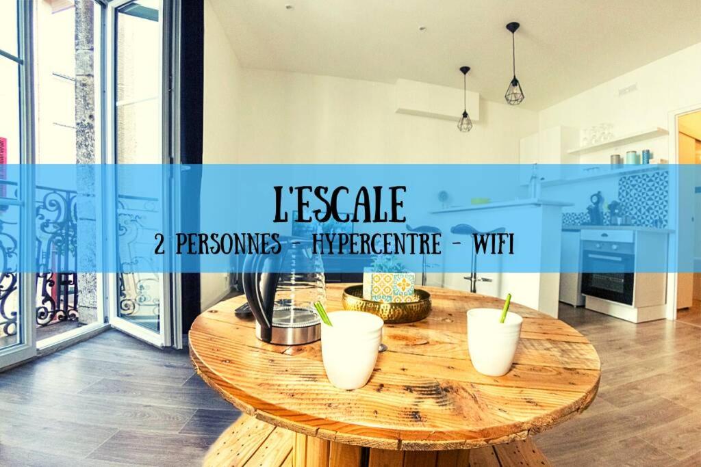 - une table en bois avec trois vases blancs dans la cuisine dans l'établissement L'ESCALE - TOPDESTINATION-BOURG - Centre ville - Classé 3 étoiles, à Bourg-en-Bresse