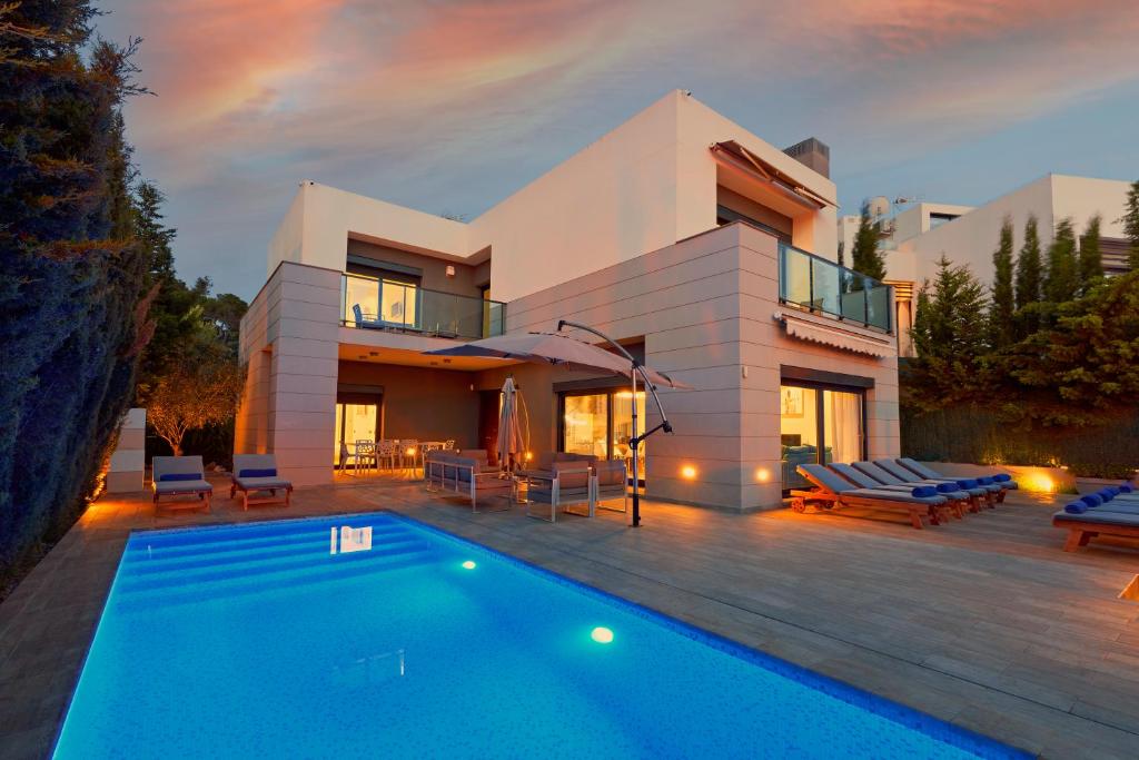 a villa with a swimming pool in front of a house at Casa Lui in Ibiza Town