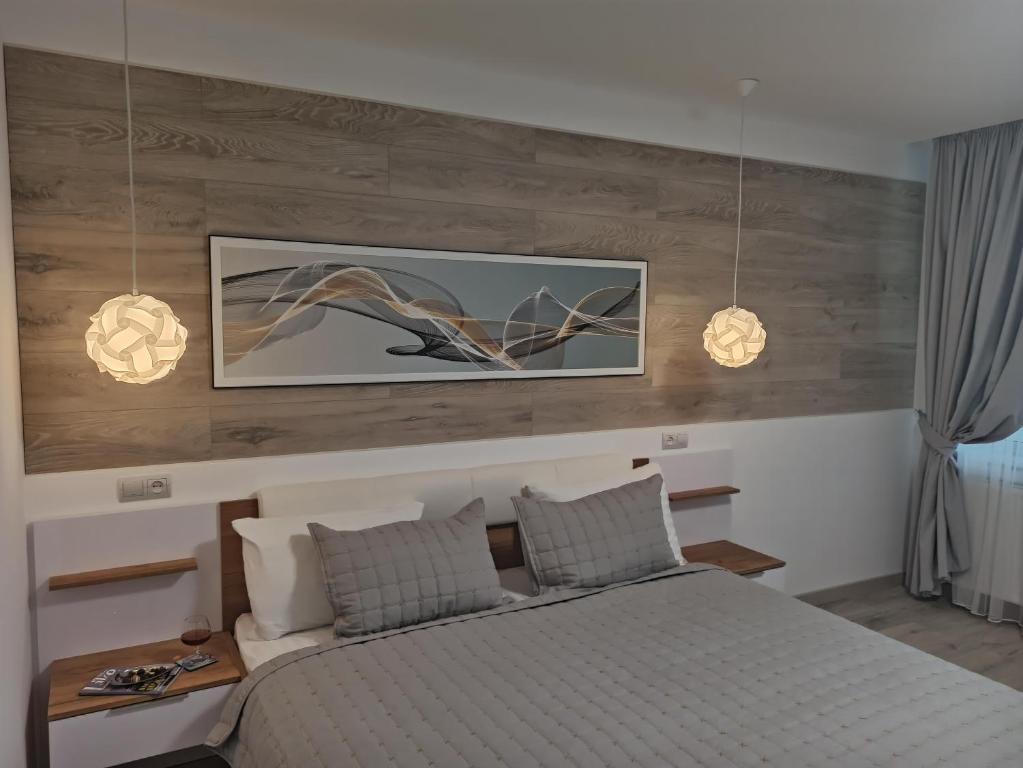 sypialnia z łóżkiem z dwoma światłami powyżej w obiekcie Marko de Luxe w Iwano-Frankiwsku