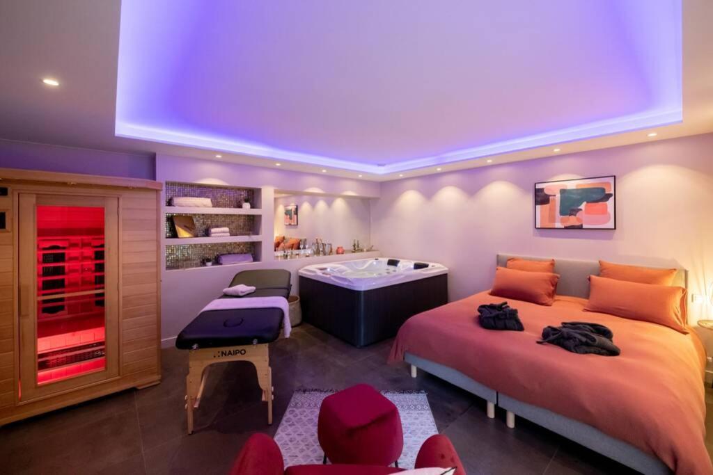 a bedroom with two beds and a bath tub at MAISON AVEC SPA PRIVATIF ( JACUZZI ET SAUNA) in Bailleval