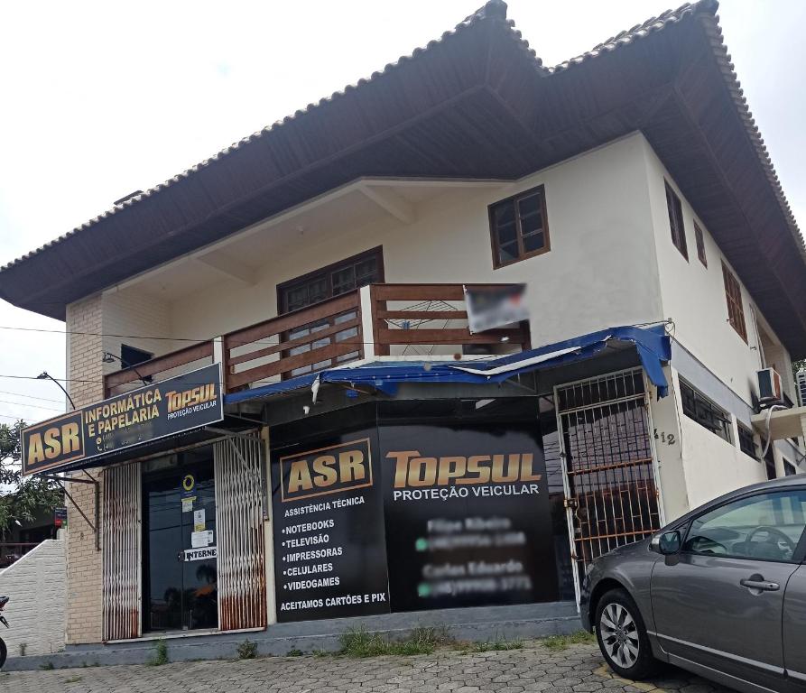 un edificio con un coche aparcado delante de él en Residencial Santinho, en Florianópolis