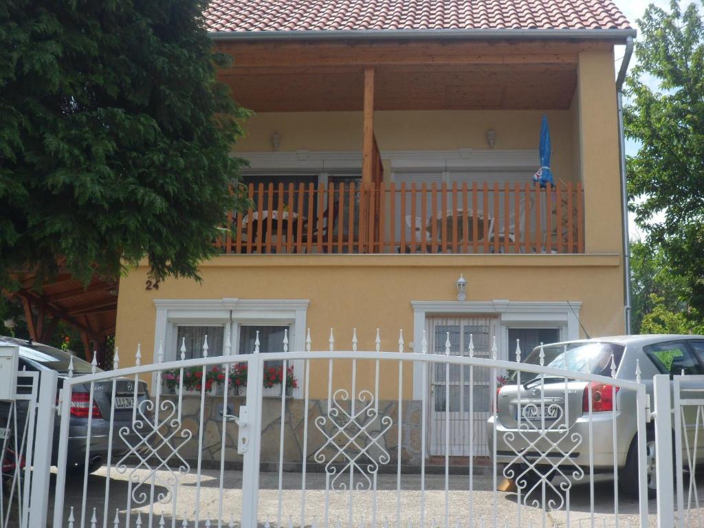 ザラカロシュにあるIldiko Appertementsのバルコニー付きの家、車が正面に駐車しています。