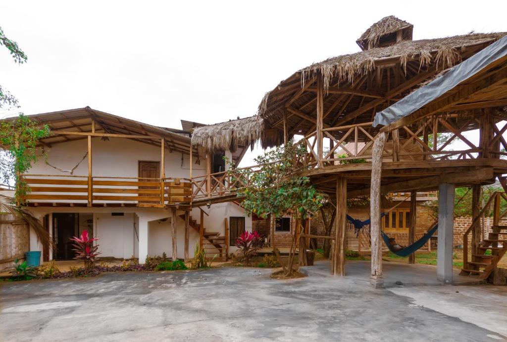 uma casa grande com telhado de palha em Hostal Tortuga Dorada em Puerto López