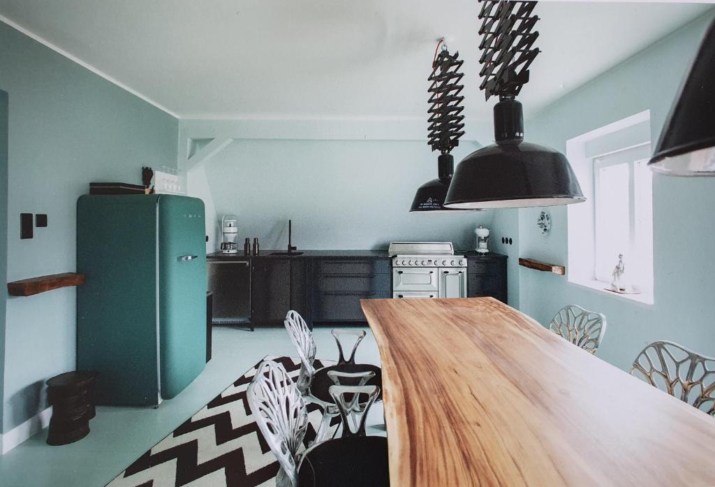 eine Küche mit einem Holztisch und einem grünen Kühlschrank in der Unterkunft Haus Noge Sylt - Offizierhaus Design Appartments strandnah in Westerland