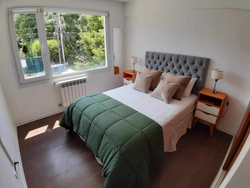 a bedroom with a large bed with a large window at Departamento Centrico en Bariloche IIæ in San Carlos de Bariloche