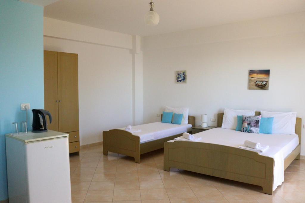 Cette chambre comprend 2 lits et une télévision. dans l'établissement Lumra Rooms, à Lukovë