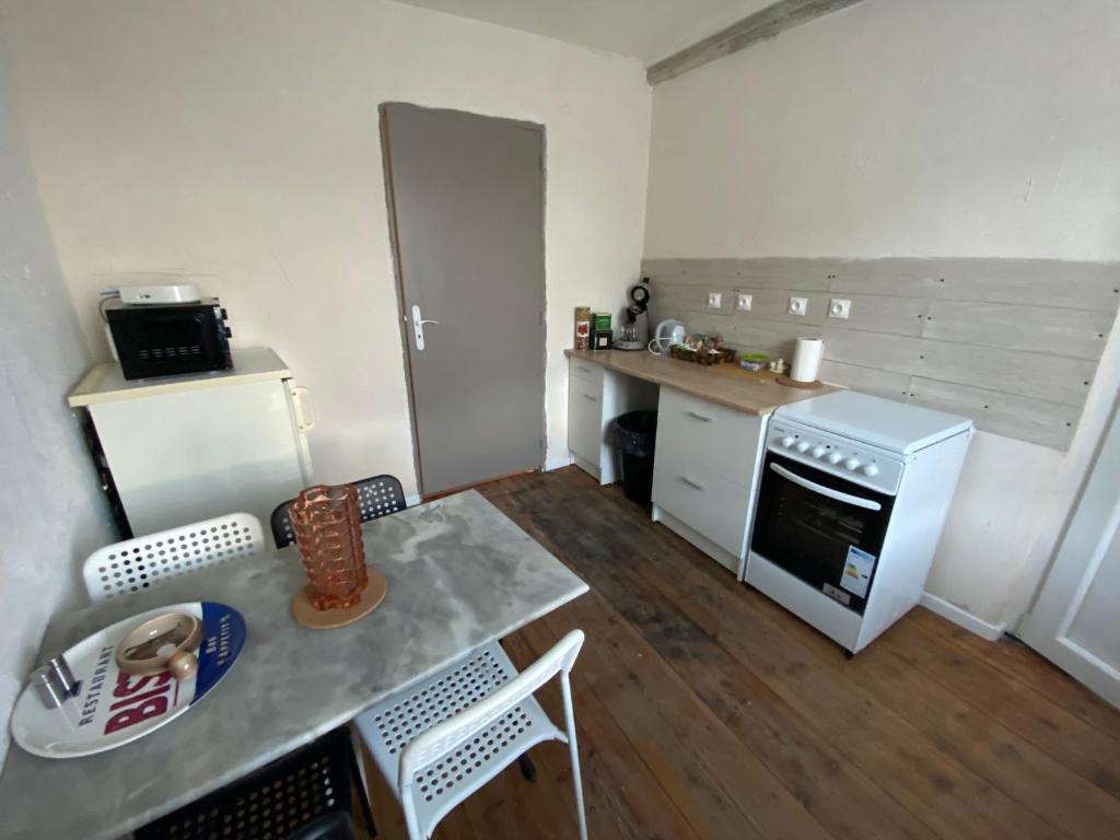 a small kitchen with a table and a stove at Appart au 1 etage in Saint-Rémy-sur-Durolle