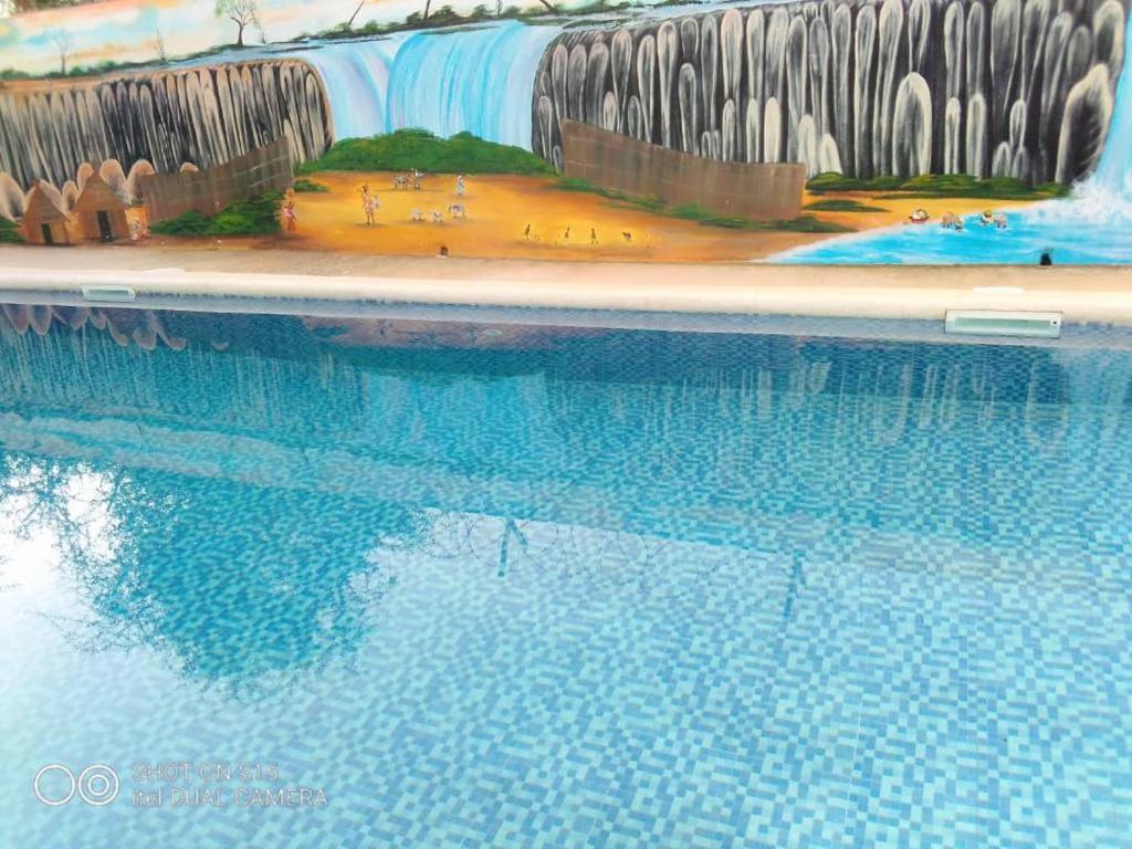 a swimming pool with a painting on the side of it at Villa Diambars in Sali Tapé