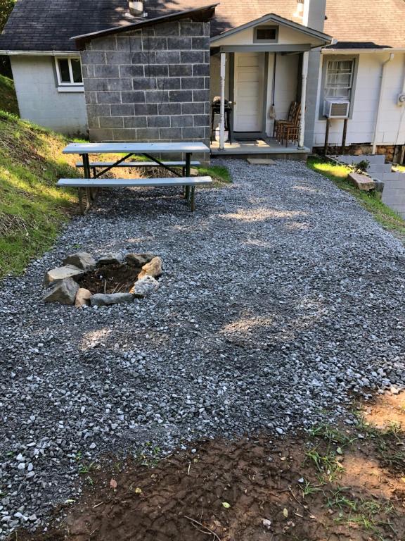 a picnic table and a bench in front of a house at Cochran Farm House in Bryson City