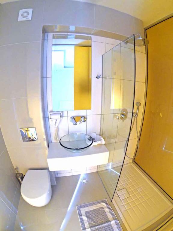 a bathroom with a toilet and a sink and a shower at Macedon in Limenas