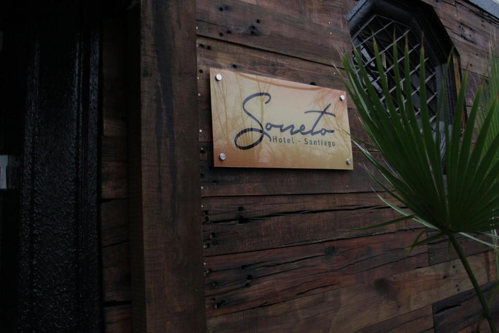 ein Schild an der Seite einer Holzwand in der Unterkunft Hotel Sonetto in Santiago