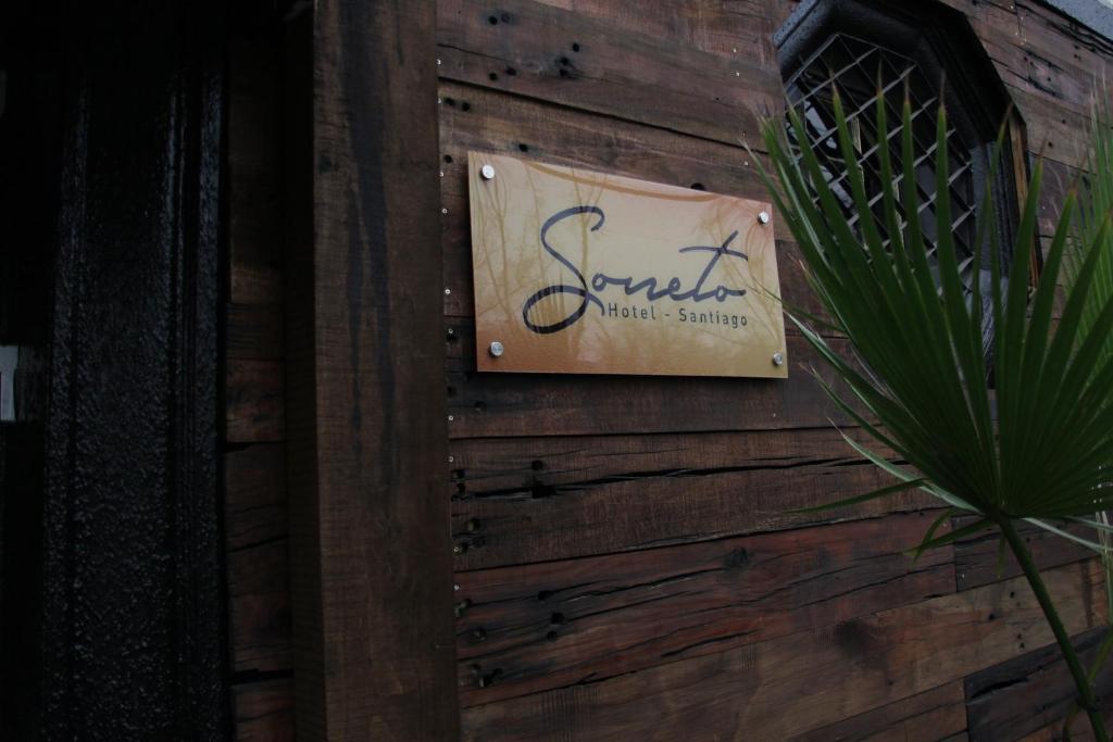 a sign on the side of a wooden wall at Hotel Sonetto in Santiago