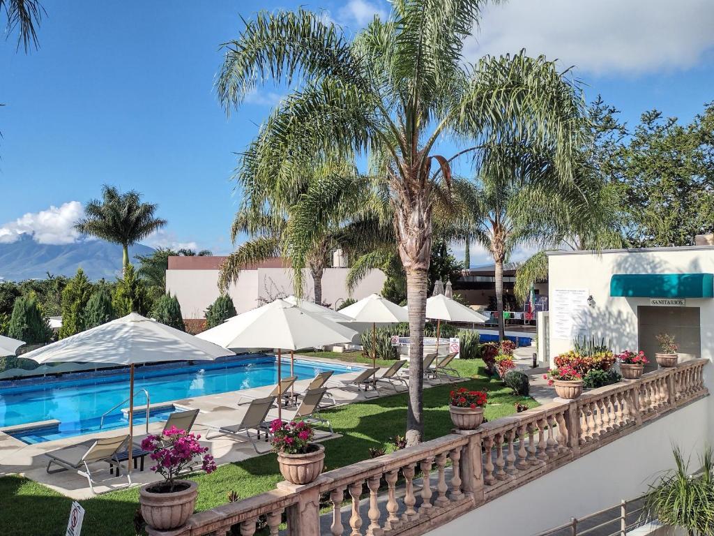 阿希吉克的住宿－漁夫酒店，享有带遮阳伞和椅子的游泳池的景色