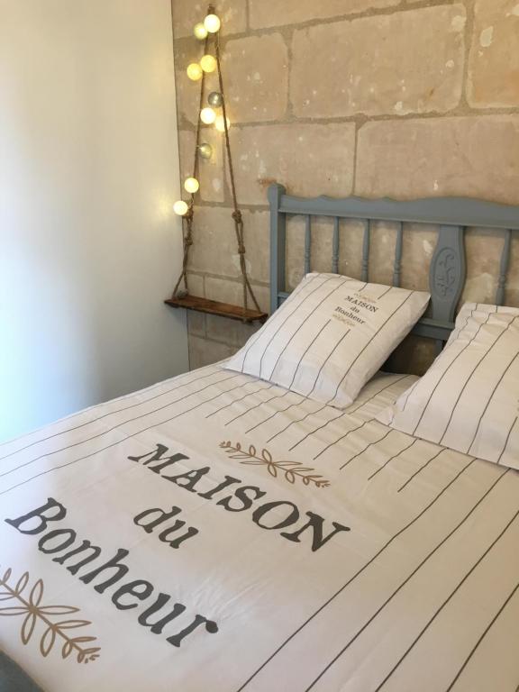 a bed with a white bedspread with the words malcolmcolmcolmyss at Vieux Tours, Charmant T2 40m2, 4 pers, lumineux in Tours