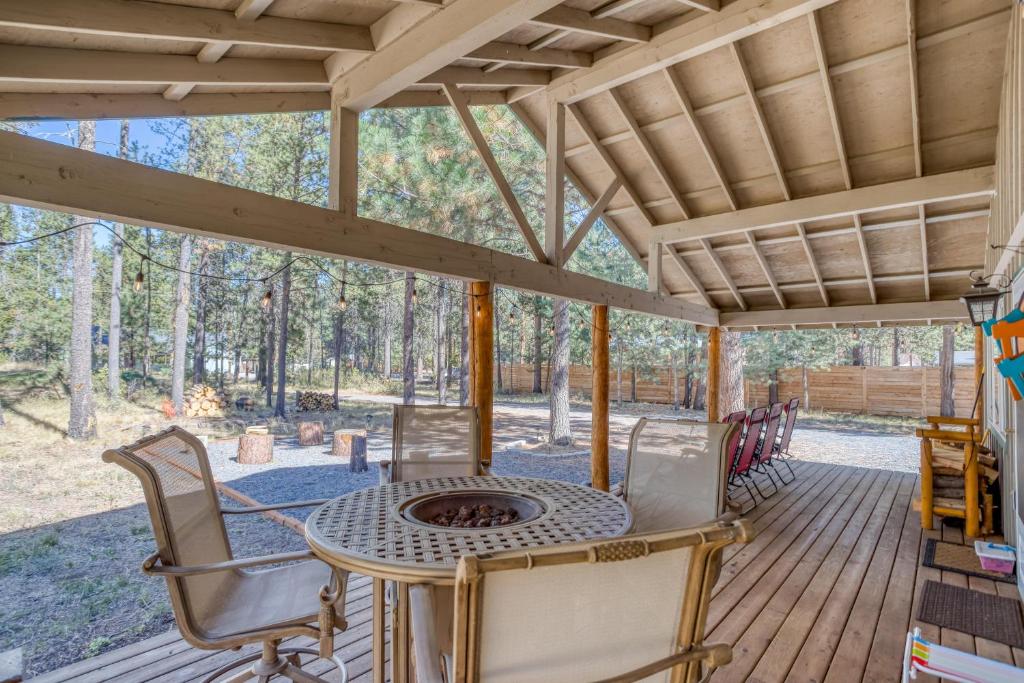 a screened porch with a table and chairs at Indio Cabin in Bend