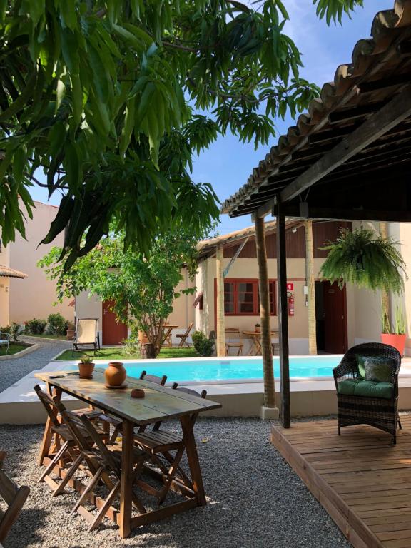 - une table et une chaise à côté de la piscine dans l'établissement Pousada Vila Sergipana, à Barra dos Coqueiros