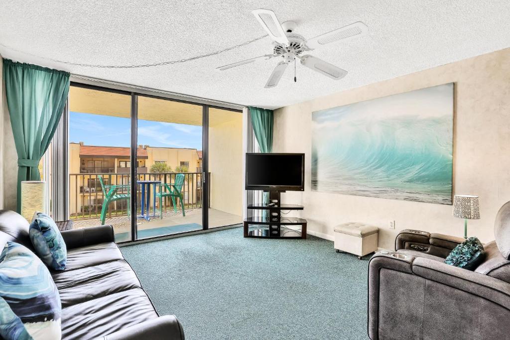 a living room with a couch and a tv at Cape Palms in Cape Canaveral