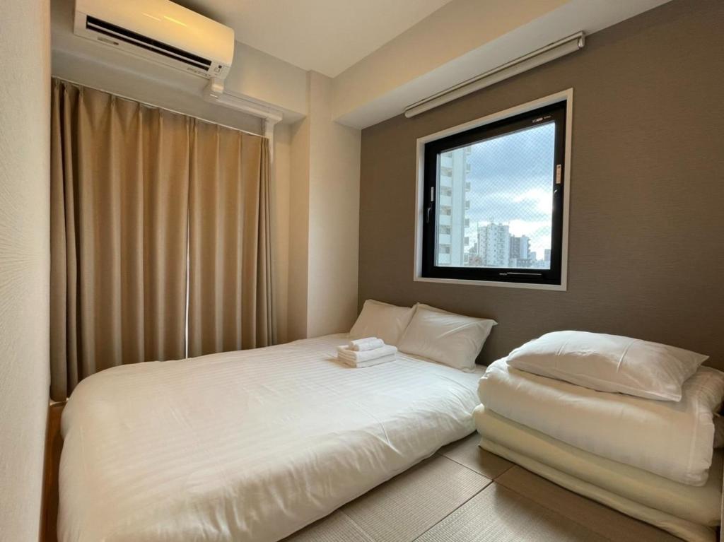 1 dormitorio con cama blanca y ventana en The Light Inn - Vacation STAY 94696, en Tokio