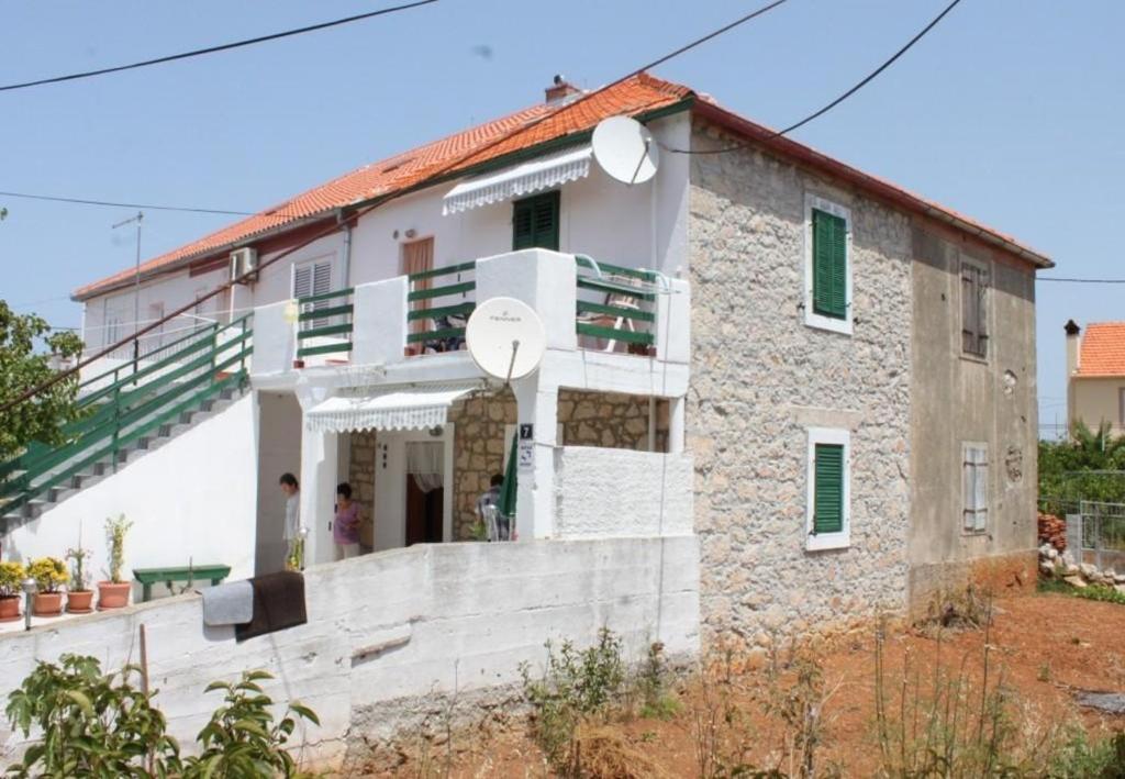 a stone house with a staircase in front of it at Apartments Tonci - 30 m from beach in Kali