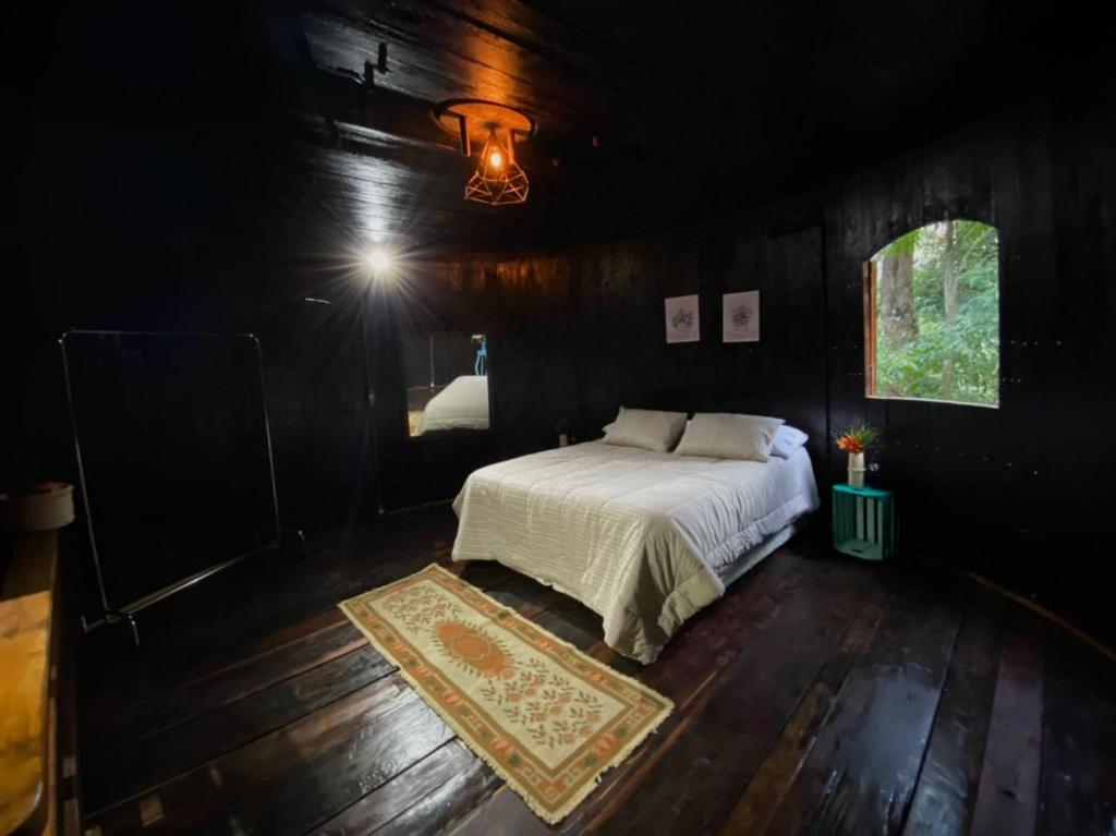 a bedroom with a bed in a dark room at Pipa Malbec in Petrópolis