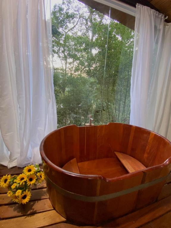 a wooden tub sitting in front of a window at Pipa Malbec in Petrópolis