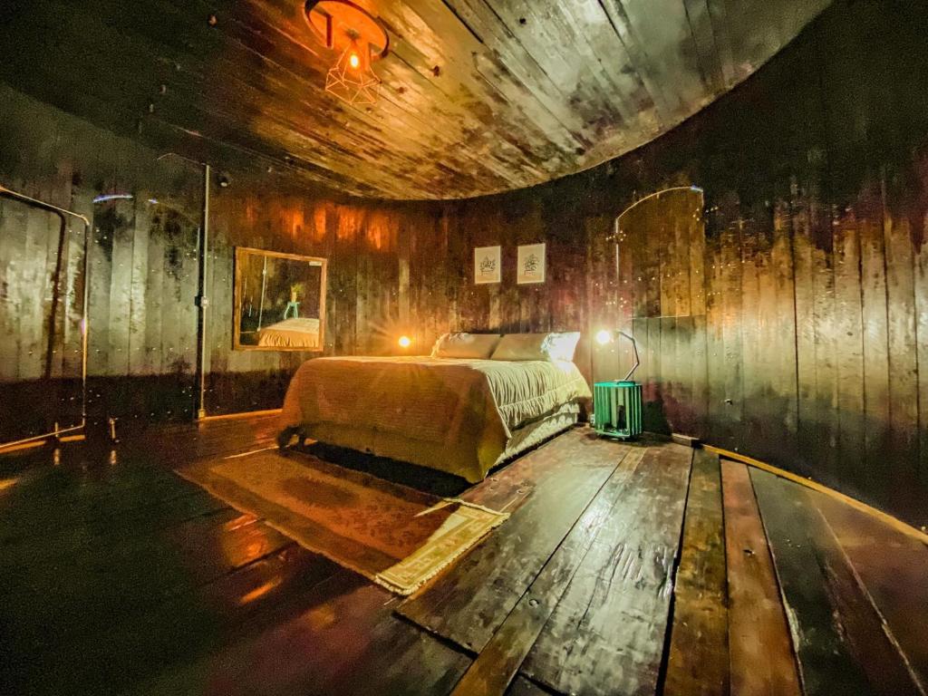 a bedroom with a bed and a wooden wall at Pipa Malbec in Petrópolis