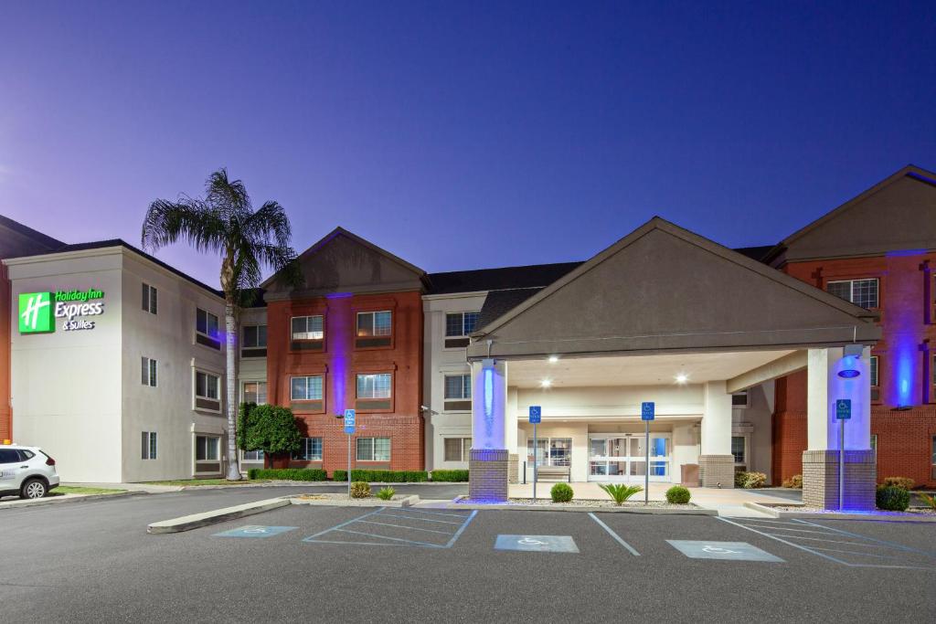 un hotel con un estacionamiento delante de él en Holiday Inn Express & Suites - Tulare, an IHG Hotel, en Tulare