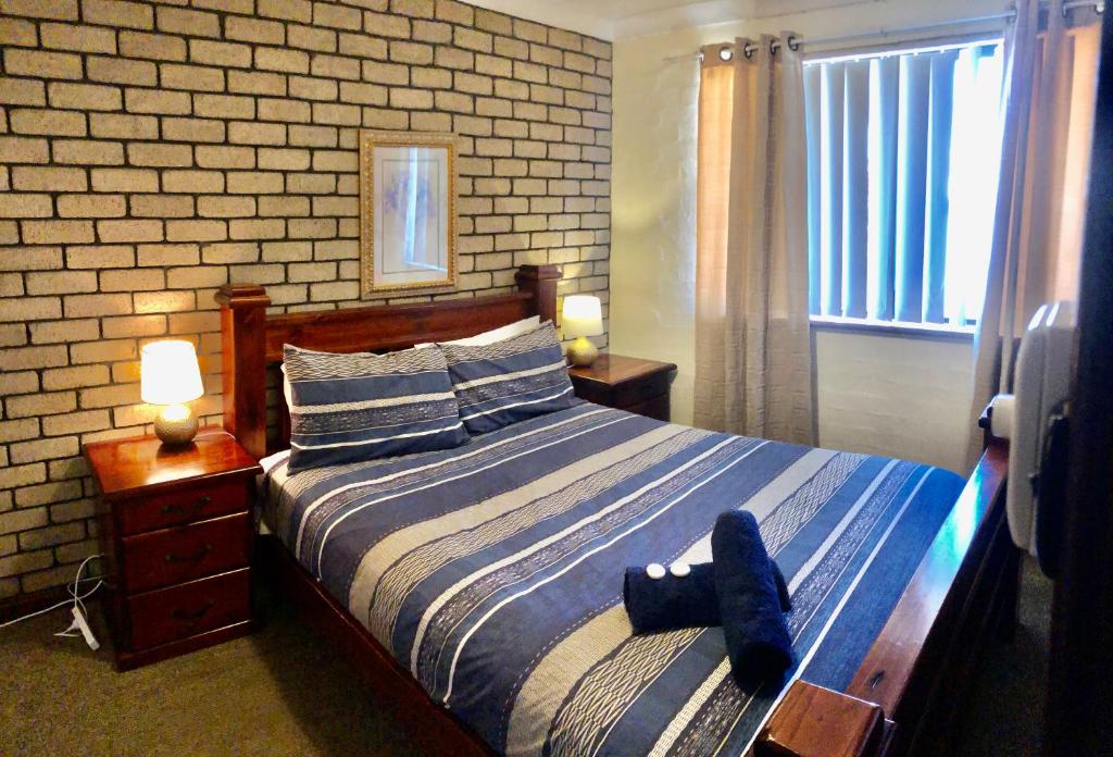 a bedroom with a bed with a blue towel on it at Geraldton Beachfront Villas in Geraldton