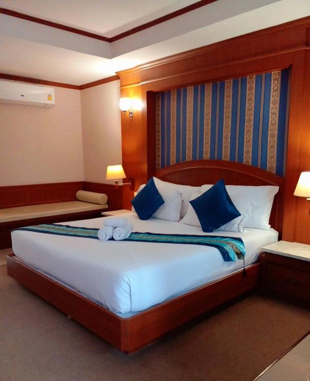 Un dormitorio con una cama grande con almohadas azules. en The Lion King Hotel Udonthani, en Udon Thani