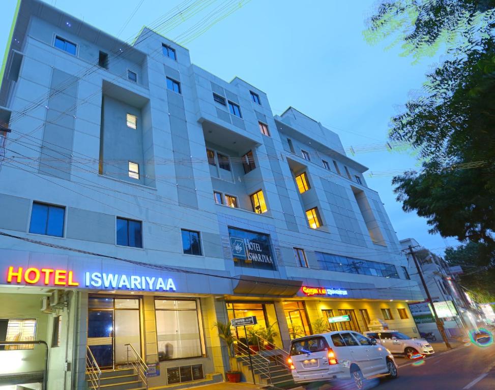 a hotel with cars parked in front of it at Hotel Aishwaryaa in Erode