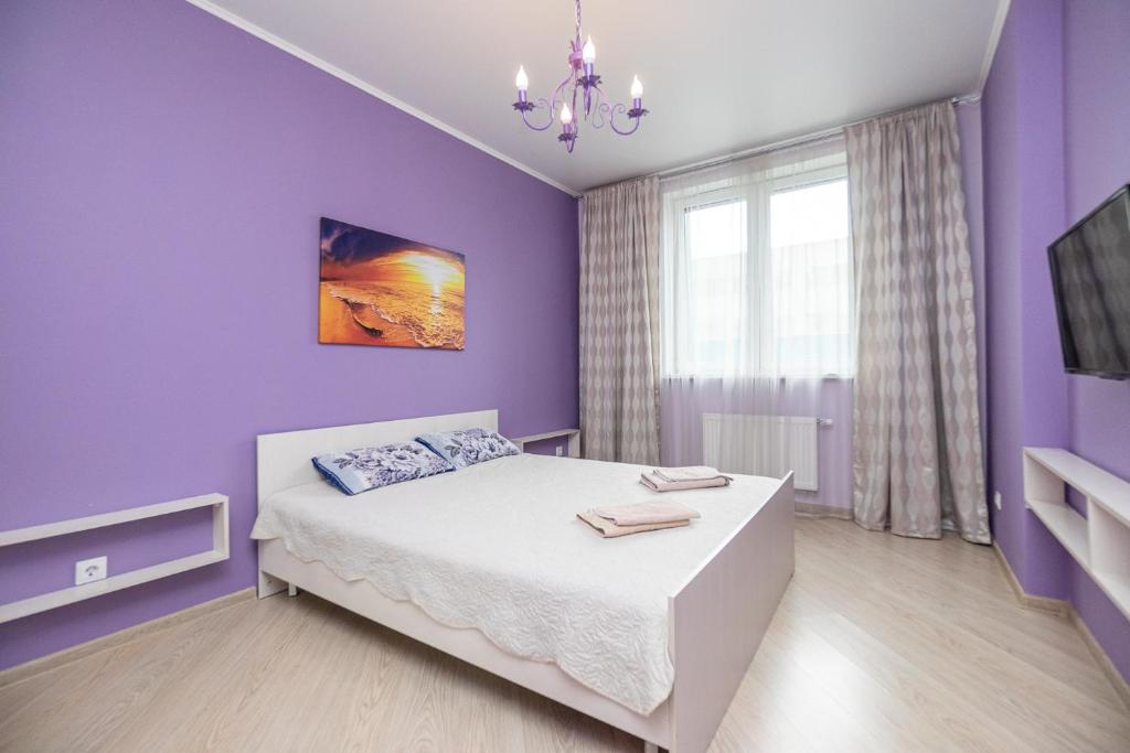 - une chambre violette avec un lit et une télévision dans l'établissement Apartment on Khakima 50, à Kazan