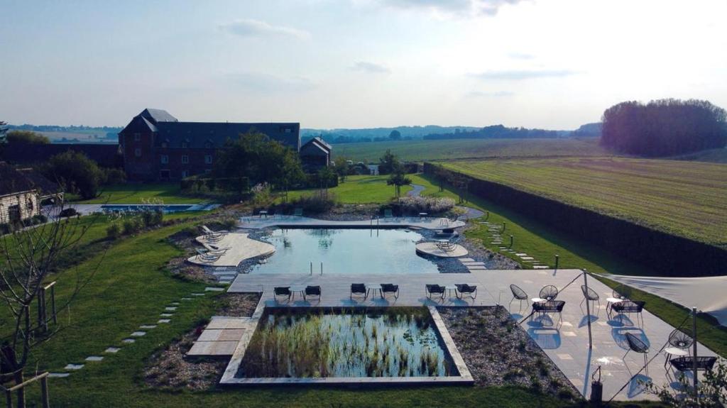 einen Luftblick auf einen Pool neben einem Feld in der Unterkunft Domaine Sur Les Sarts in Ohey