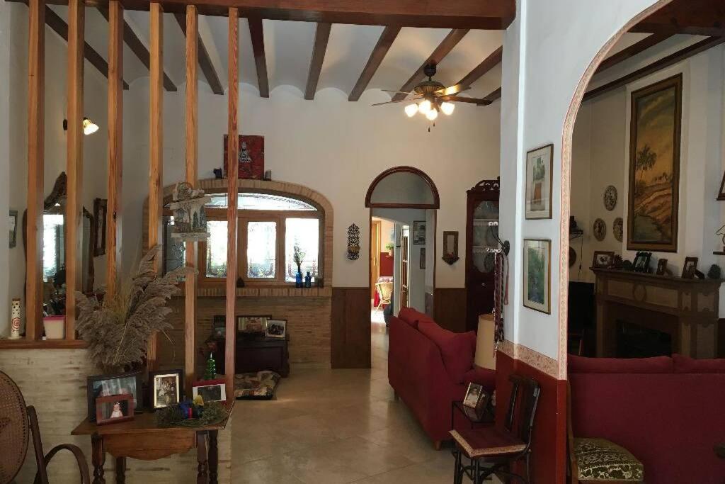 una sala de estar con un sofá rojo en una habitación en Casa de Pueblo en Navarres, en Navarrés