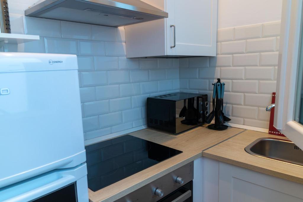 a kitchen with a sink and a microwave at Apartamentos El Alcazar de Jerez in Jerez de la Frontera
