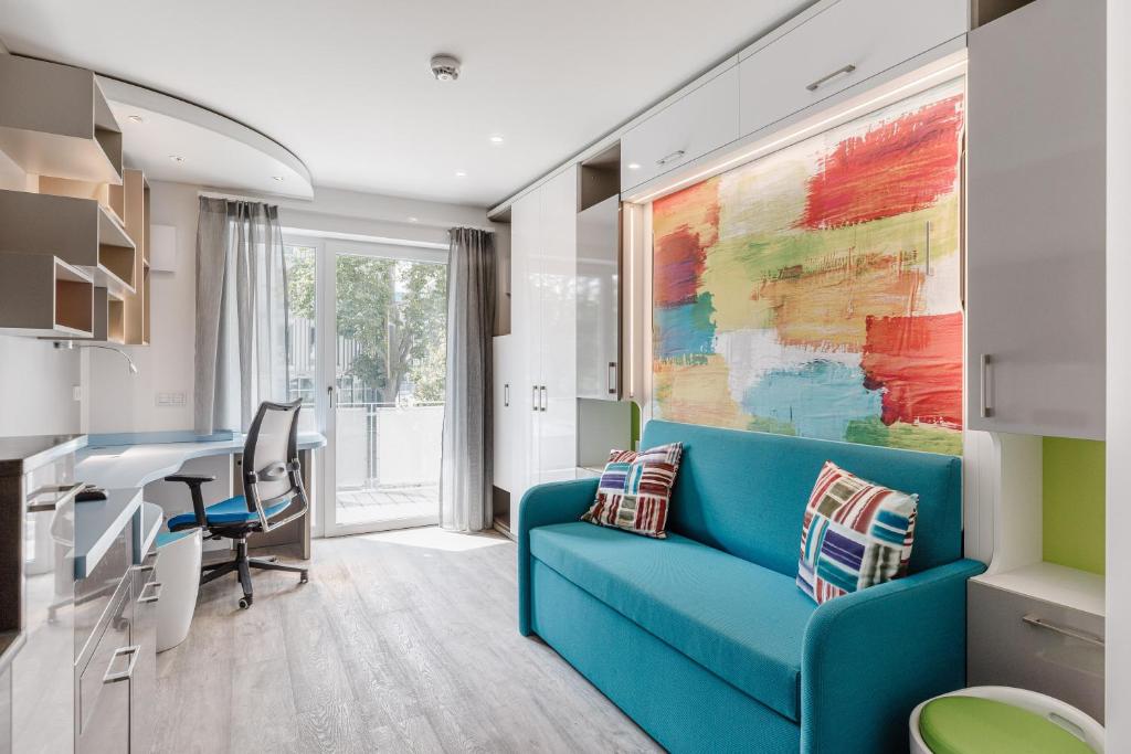 愛爾朗根的住宿－The Brucklyn Apartments，客厅配有蓝色的沙发和书桌