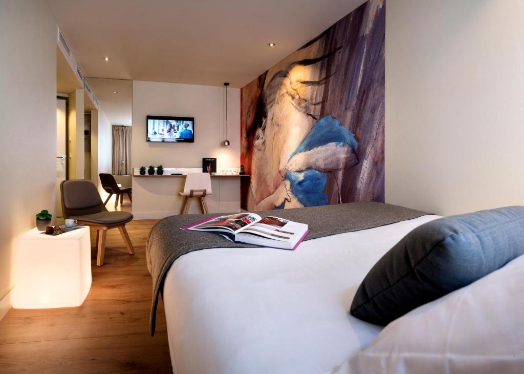 een slaapkamer met een bed en een woonkamer bij Hotel Max in Parijs