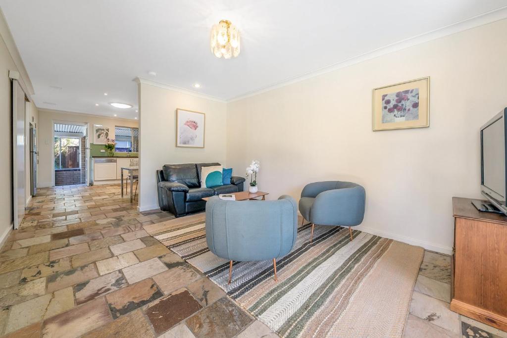 uma sala de estar com duas cadeiras e uma mesa em Layman Park Villa em Perth