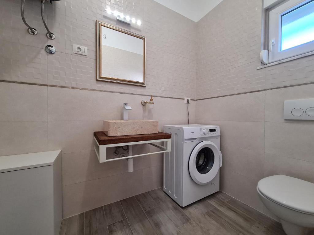 W łazience znajduje się pralka i umywalka. w obiekcie House Plavi 2130 w Medulinie