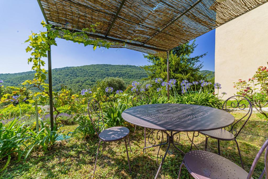 Le Bar-sur-LoupにあるHolidays In Provence Alpes Maritimesの眺めの良いパーゴラの下にテーブルと椅子