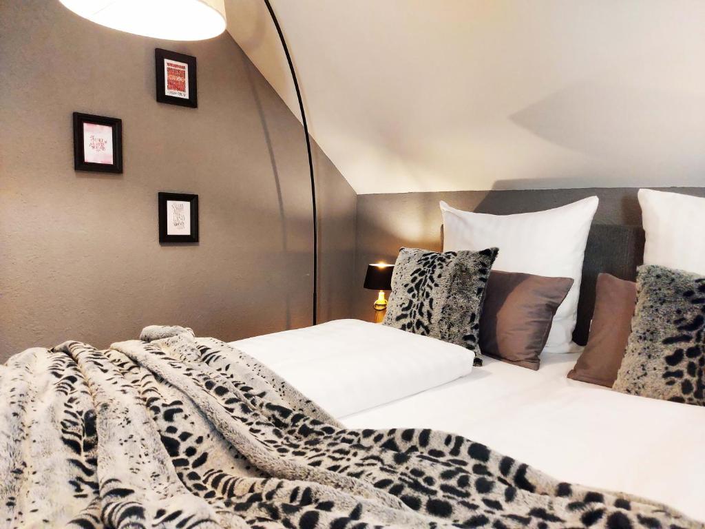 um quarto com uma cama com um cobertor de leopardo em Select-Home 1 - Wellnesshaus Sandmühle - mit privater Sauna em Bruck in der Oberpfalz