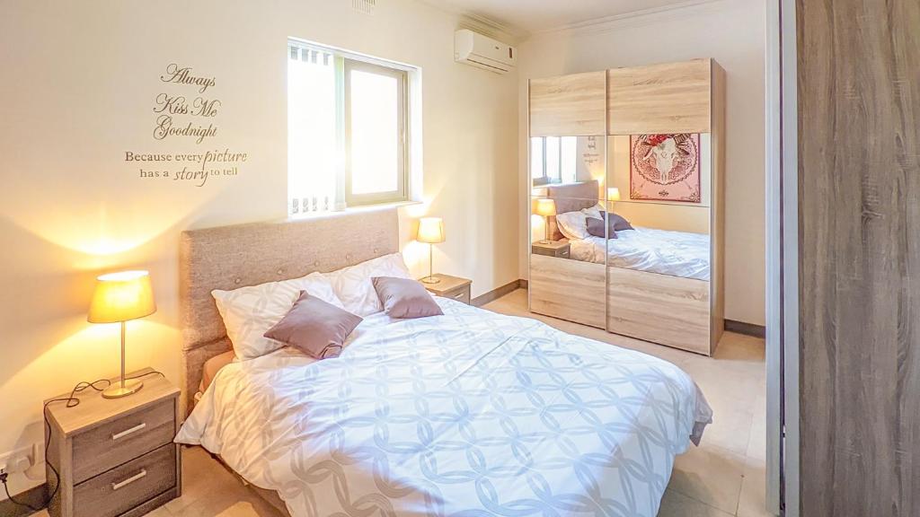 a bedroom with a large bed and a mirror at Holiday Hub Gozo - 3 Bedrooms in Xewkija