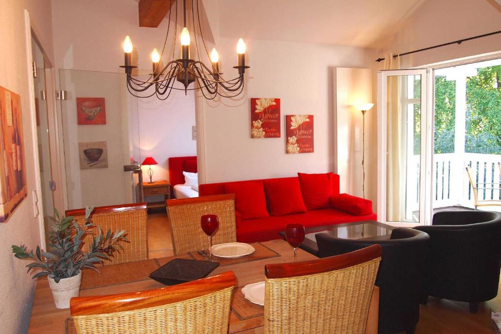 een woonkamer met een rode bank en een tafel bij Residenz an der Prorer Wiek Ferienwohnung 12 in Binz
