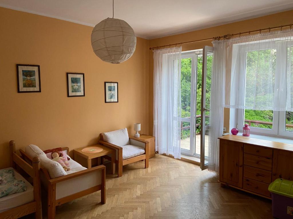 ein Babyzimmer mit einem Kinderbett, einem Stuhl und einem Fenster in der Unterkunft Pokoje Gościnne Hetmanska in Gdynia