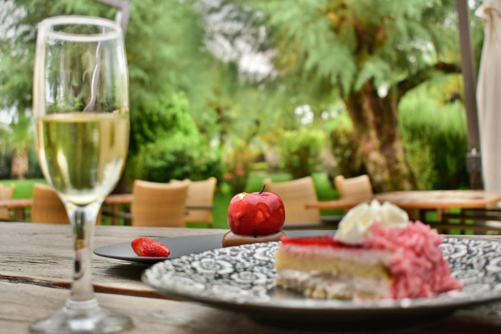 a table with a glass of wine and a piece of cake at Plaza Resort in Anavyssos