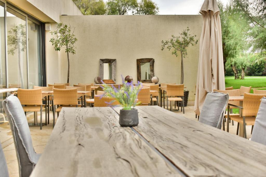 a table with a vase of flowers on a patio at Plaza Resort in Anavyssos