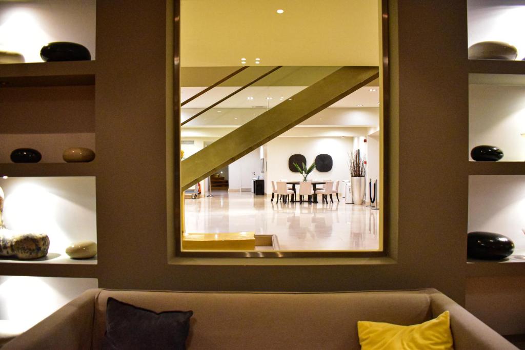 a large mirror in a living room with a couch at Plaza Resort in Anavyssos